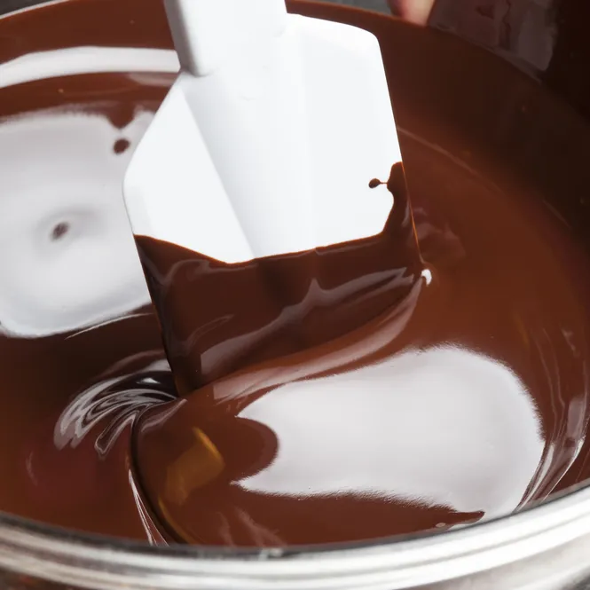 Khi socola đã chảy, bạn bắc nồi ra và cho bơ đã cắt nhỏ vào
