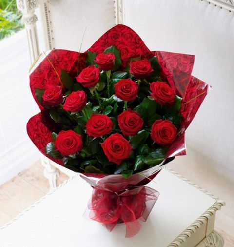 Một bó hoa hồng đỏ nở rộ kèm theo một thông điệp về lòng biết ơn
